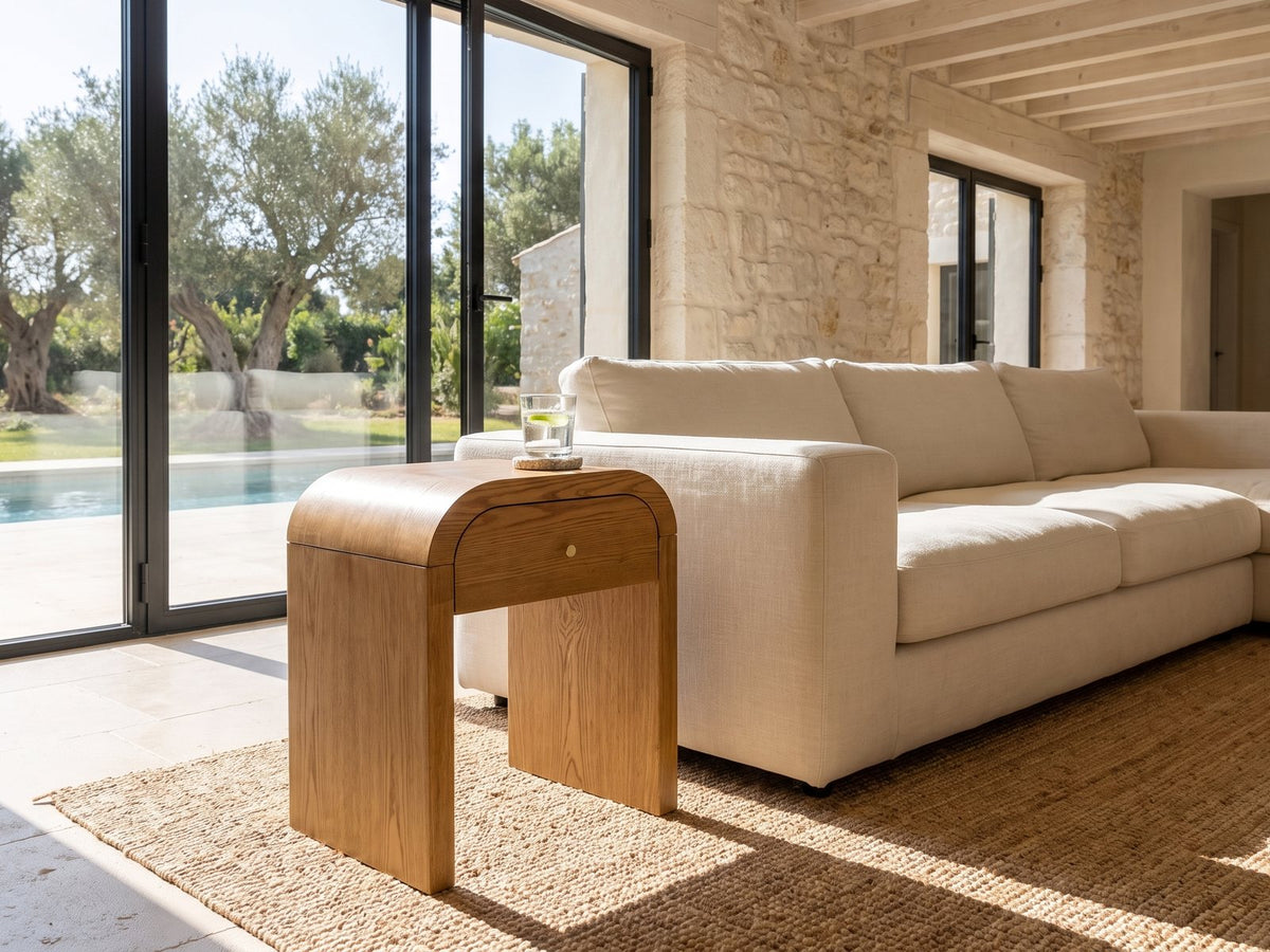 Cariati Ash Veneer Curved-Top Side Table beside a linen sofa in a poolside villa