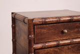 The top corner of the Carloforte nightstand: the thin top, the turned faux-bamboo rail and corner post with raised rings, the top drawer with its brass knob and the middle rail