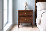 Carloforte faux-bamboo mango nightstand with a ceramic lamp in a Charleston bedroom with pale blue beadboard panelling and pale pine floors