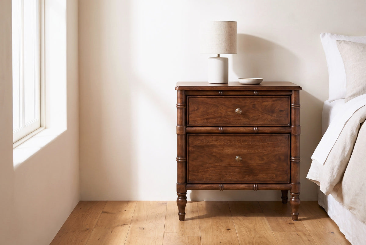 Carloforte faux-bamboo mango nightstand with a lamp and a small dish beside a bed in a Napa Valley bedroom with a warm ivory plaster wall
