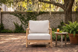 Caronia acacia club chair in a walled courtyard with a grey brick wall, creeping fig and herringbone brick paving under a live oak (side table not included)