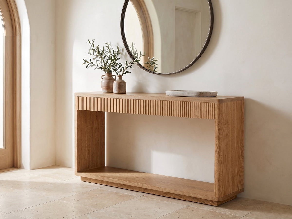 Carovigno Fluted Wood Veneer Console Table under a round mirror in a travertine entryway