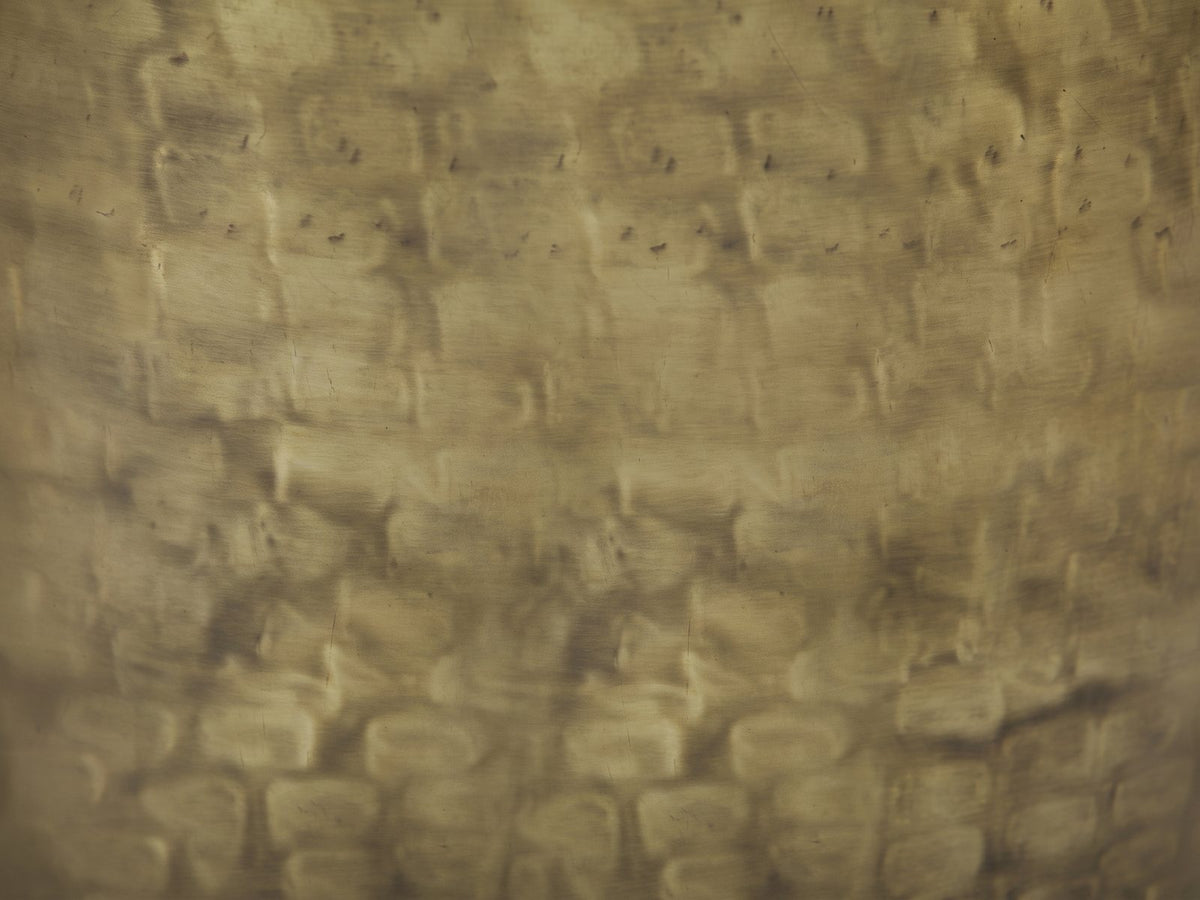 Close-up of the Carovilli Hammered Metal Drum Side Table: the hand-hammered antique gold surface