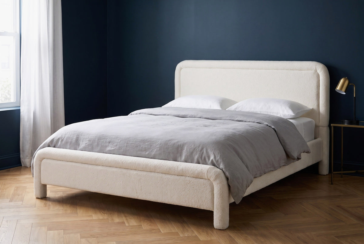 Casacalenda white boucle bed against a deep ink-navy wall in a Chicago greystone bedroom with a herringbone oak floor