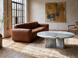Cascia Compact Blue-Grey Marble Coffee Table on a vintage rug in front of a leather sofa in an industrial loft