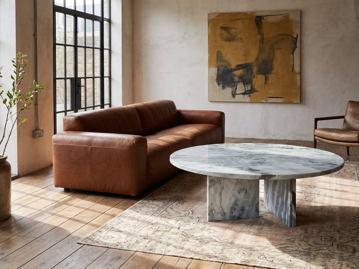 Cascia Compact Blue-Grey Marble Coffee Table on a vintage rug in front of a leather sofa in an industrial loft