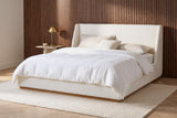 Casoli white boucle bed against a vertical walnut slat wall in a Nashville bedroom with a herringbone oak floor