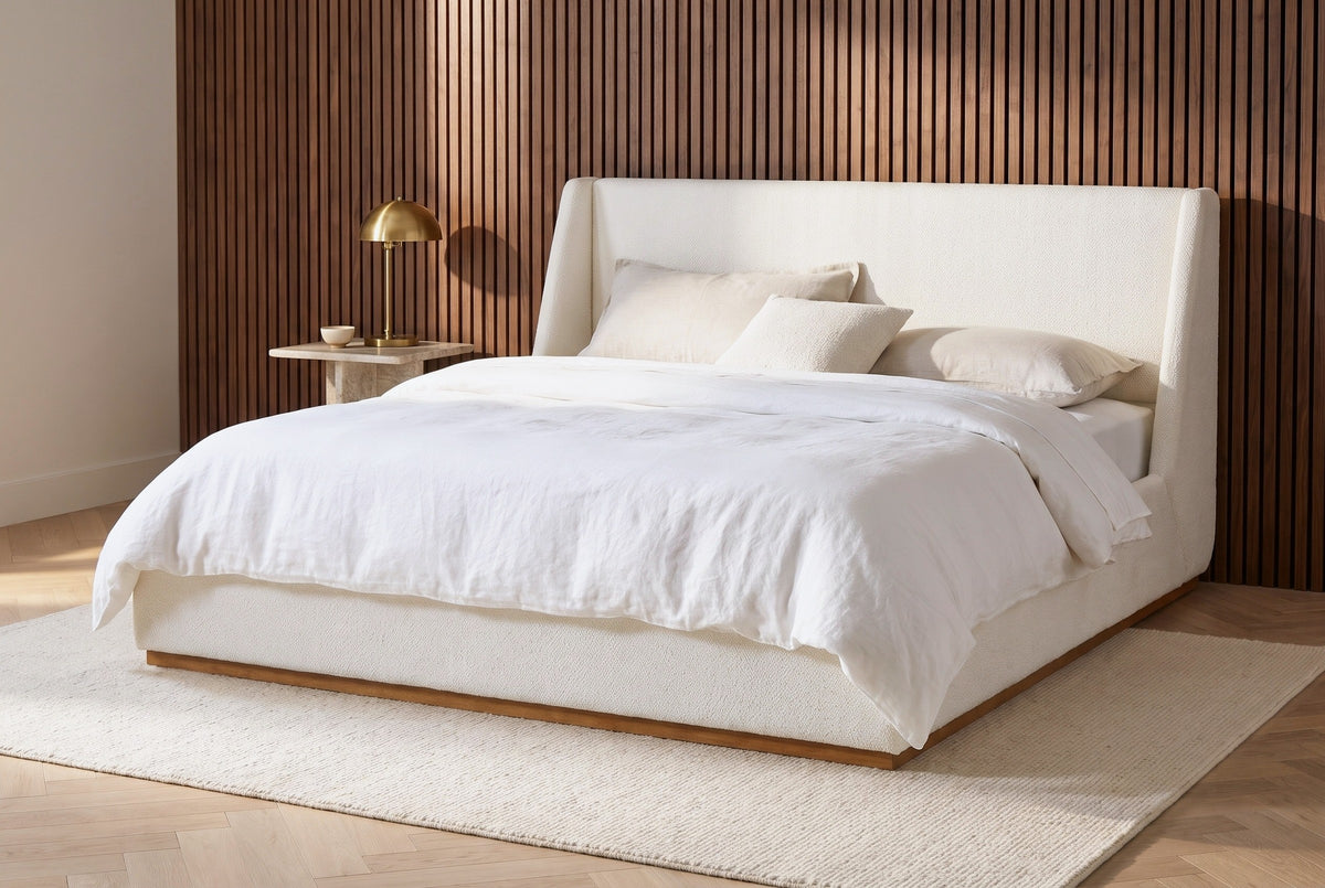 Casoli white boucle bed against a vertical walnut slat wall in a Nashville bedroom with a herringbone oak floor