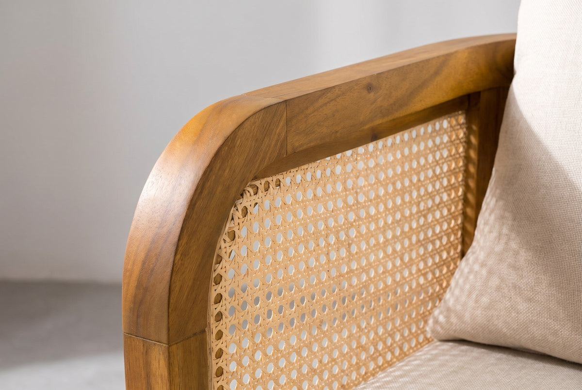 Close-up of the rounded acacia arm rail and the open cane panel on a Castelbuono chair