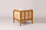 A Castelbuono arm chair from behind: three cane panels between acacia stiles, the rounded arm and the cane arm panel