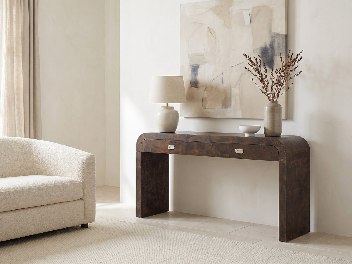 Castellana Burl Veneer Waterfall Console Table against a plaster wall under an abstract canvas in a bright living room