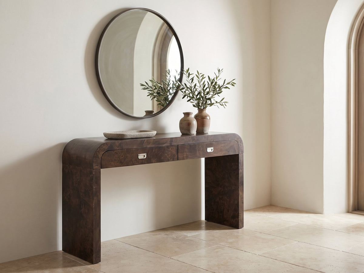 Castellana Burl Veneer Waterfall Console Table under a round mirror in a travertine entryway