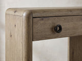 Close-up of the Castellaneta Knotty Oak Veneer Console Table: the rounded top corner of an end panel beside a drawer with its dark ring pull