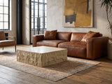 Castellina Faux Travertine Fiberglass Block Coffee Table on a vintage rug in front of a leather sofa in an industrial loft
