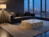 Castellina Faux Travertine Fiberglass Block Coffee Table on a wool rug in front of a velvet sofa in a city penthouse at blue hour