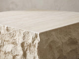 Close-up of the Castellina Faux Travertine Fiberglass Block Coffee Table: a chiselled corner of the block under the travertine-look top