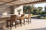Castrolibero Woven Natural Fiber and Dark Wood Counter Stool in a sunlit villa dining room