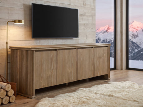Cefalu Fluted Oak Media Console seen from the side, under a wall-mounted screen in an alpine chalet at dusk