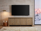 Cefalu Fluted Oak Media Console under a wall-mounted screen in an alpine chalet at dusk
