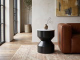 Ceglie White Marble Hourglass Side Table beside a leather sofa in an industrial loft