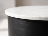 Close-up of the Ceglie White Marble Hourglass Side Table: the white marble top resting on the black iron drum