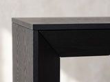 Close-up of the Cellamare Black Ash Veneer Waterfall Console Table: the mitred corner where the thin top and angled front band turn down into a slab leg