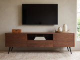 Cernobbio Curved Walnut Media Console styled with a box, a tray of vases and books under a wall-mounted screen