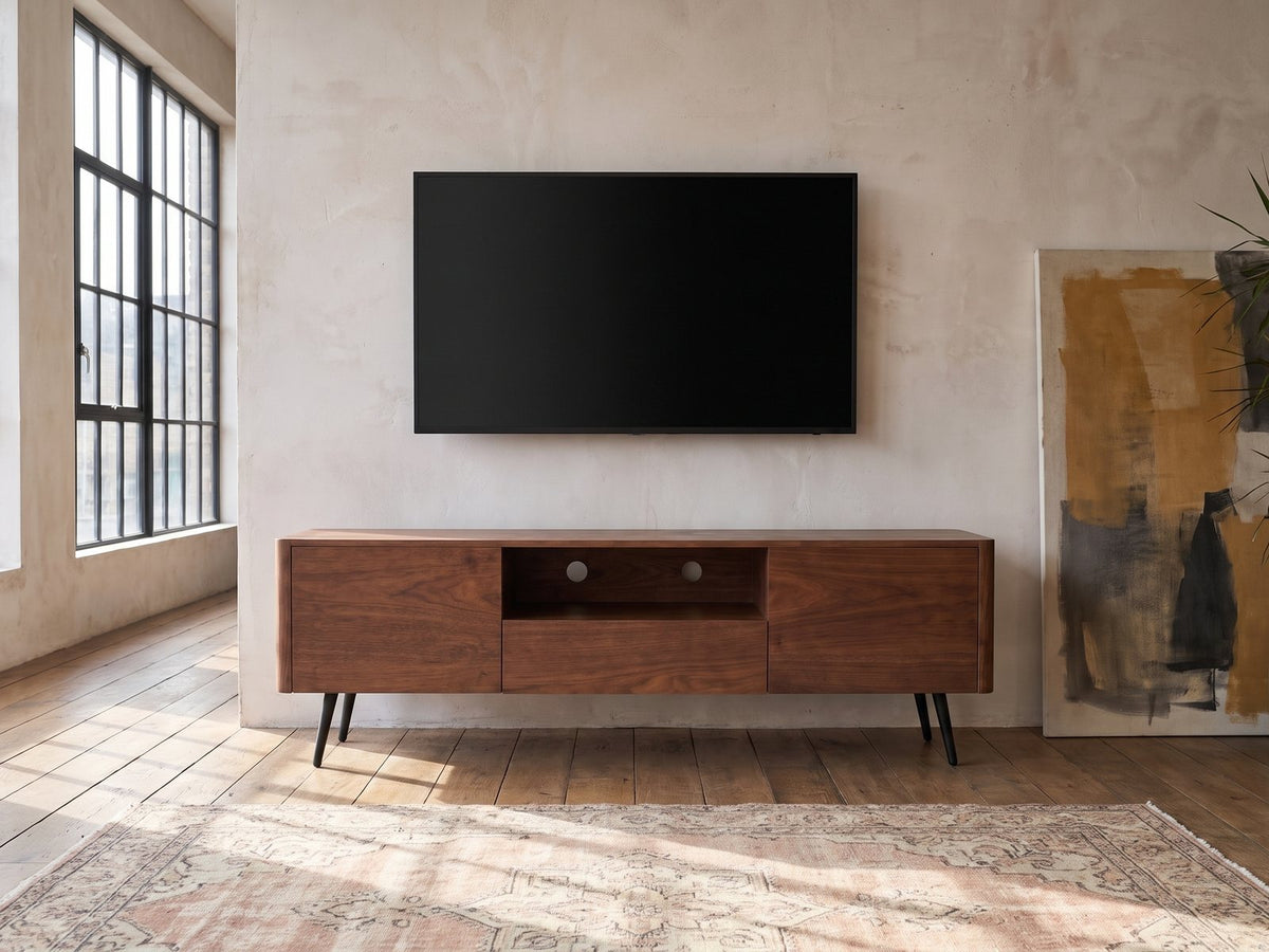 Cernobbio Curved Walnut Media Console under a wall-mounted screen in an industrial loft