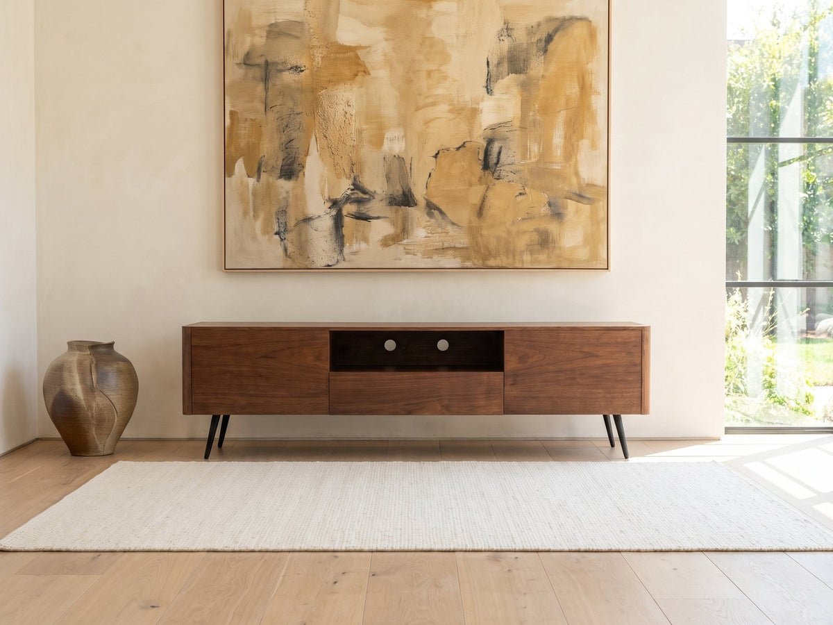 Cernobbio Curved Walnut Media Console under a large abstract painting in a bright living room