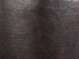 Close-up of the Cervara Rustic Bronze Metal Drum Side Table: the speckled rustic bronze finish of the drum