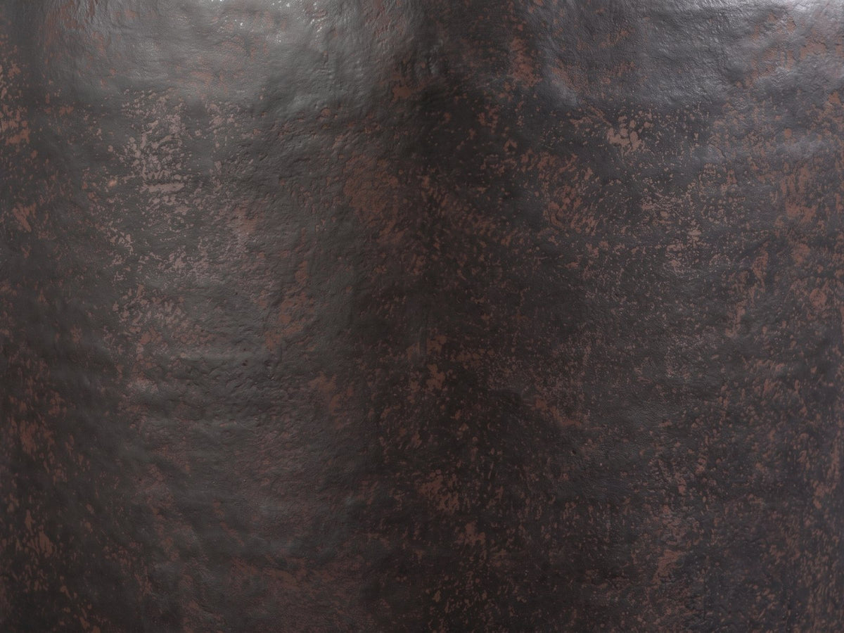 Close-up of the Cervara Rustic Bronze Metal Drum Side Table: the speckled rustic bronze finish of the drum