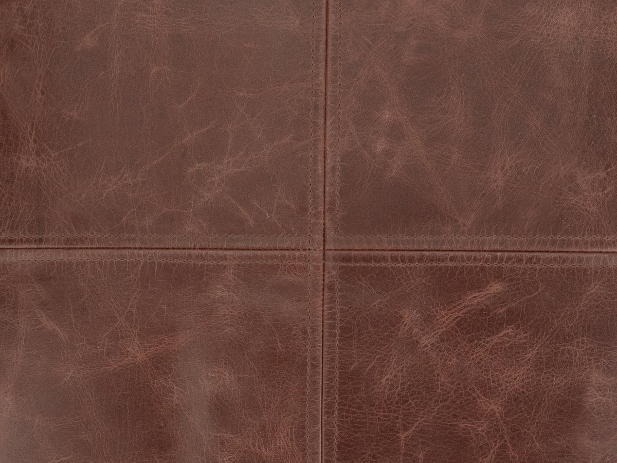 Close-up of the Cervo Distressed Brown Genuine Leather Square Pouf: the four-panel top, its two topstitched seams crossing at the centre