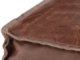 Close-up of the Cervo Distressed Brown Genuine Leather Square Pouf: the raw-edged flange seam along a top corner