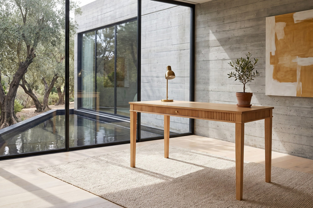 Cessaniti 63-Inch 1-Drawer Reeded Rubberwood Writing Desk in a sunlit villa study