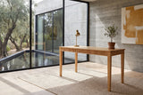 Cessaniti 63-Inch 1-Drawer Reeded Rubberwood Writing Desk in a sunlit villa study