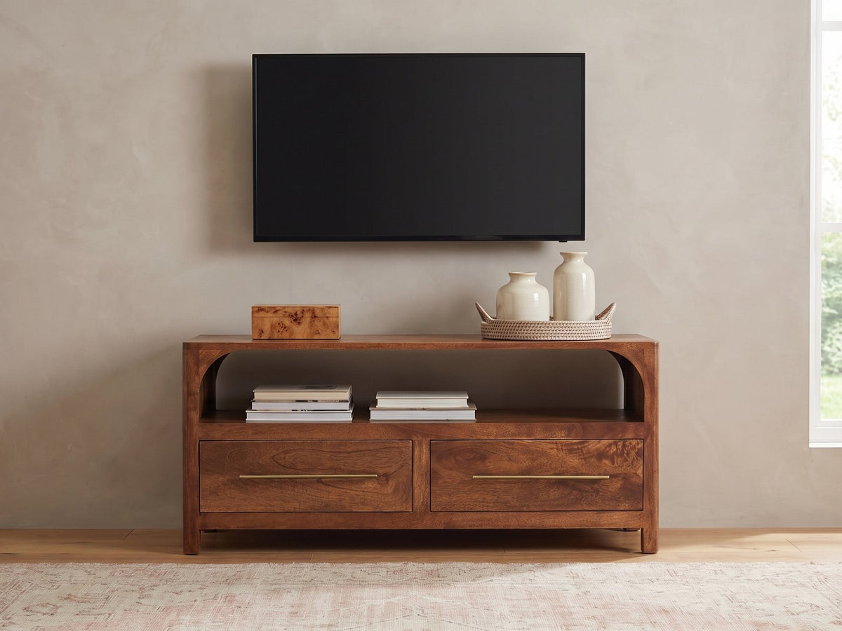 Cherasco Arch Mango Media Console styled with a box, a tray of vases and books under a wall-mounted screen