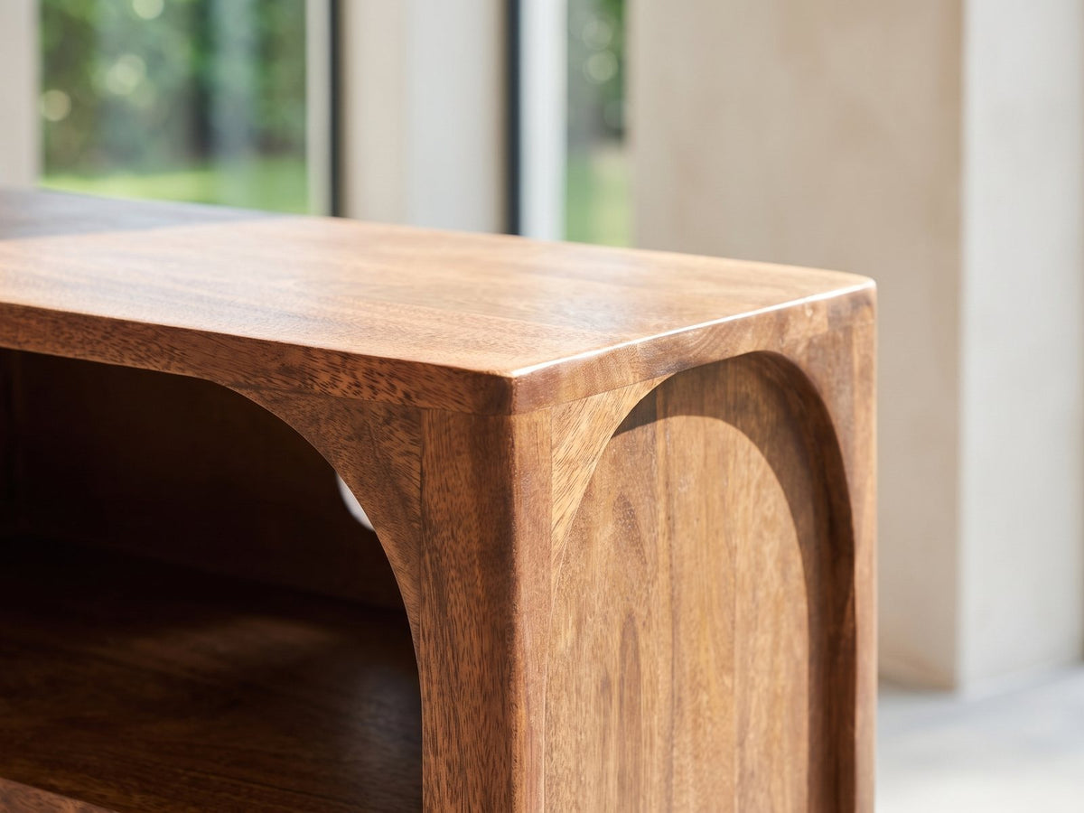 Close-up of the Cherasco Arch Mango Media Console: the rounded top corner of the arch in solid mango, the grain wrapping the curve