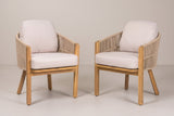 The set of two Chiaramonte acacia and rope outdoor dining armchairs with light beige cushions, three-quarter view on a light studio backdrop