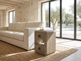 Chiaromonte Knotty Oak Veneer Two-Drawer Side Table beside a linen sofa in a poolside villa