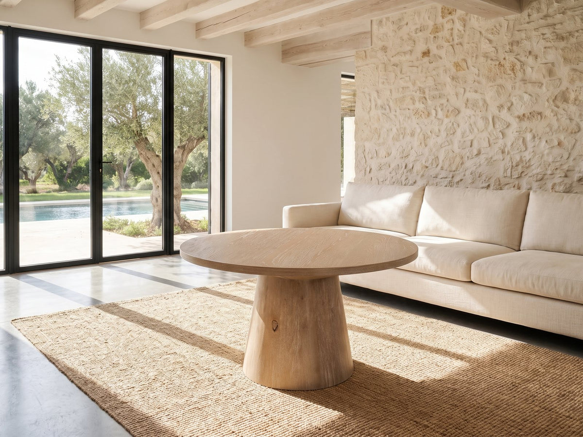 Chiavari Oak Veneer Round Pedestal Coffee Table on a jute rug in front of a linen sofa in a poolside villa