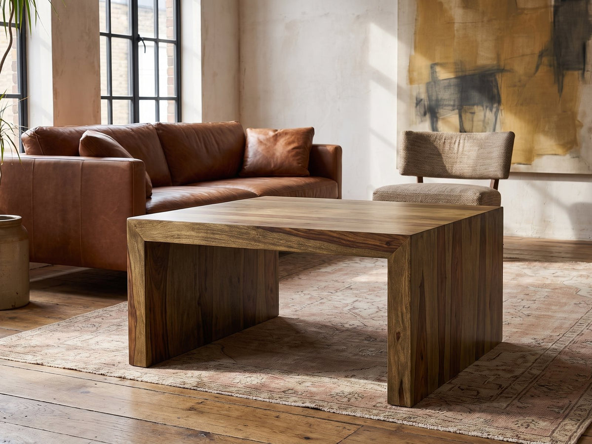 Chieri 34-Inch Square Solid Sheesham Waterfall Coffee Table on a vintage rug in front of a leather sofa in an industrial loft