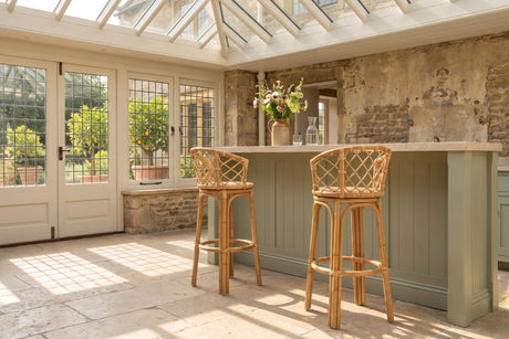 Cicala Natural Rattan Lattice-Back Bar Stool in an orangery