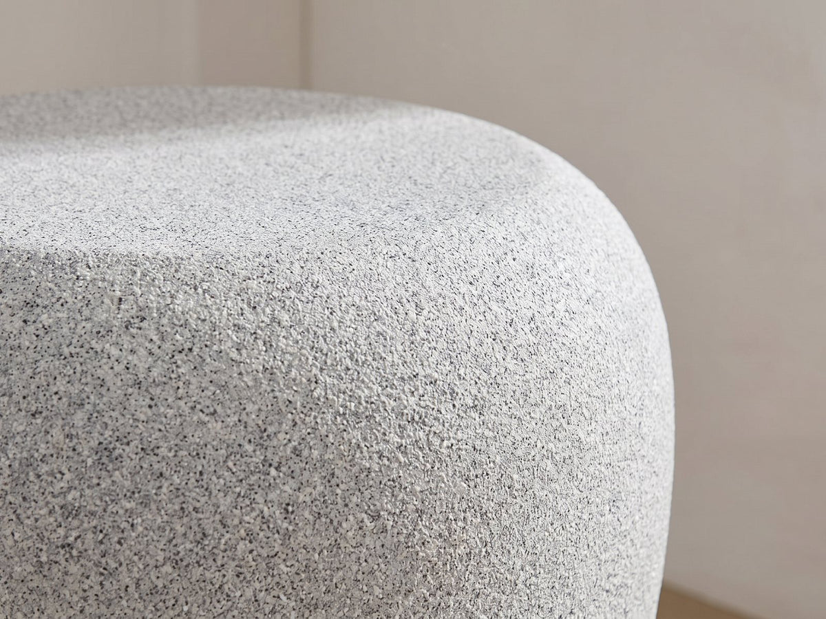 Close-up of the Cilento Grey Fiberglass Pebble Coffee Table and Side Table Set: the rounded shoulder of the jar-shaped side table