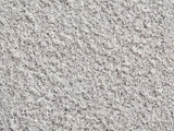 Close-up of the Cilento Speckled Grey Fiberglass Pebble Side Table: the speckled light grey stone-look finish of the fiberglass