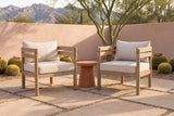 Two Cinisi acacia club chairs on buff flagstones in a Tucson courtyard, a pink lime plaster wall, a palo verde tree and the Santa Catalina mountains behind (side table and plants not included)