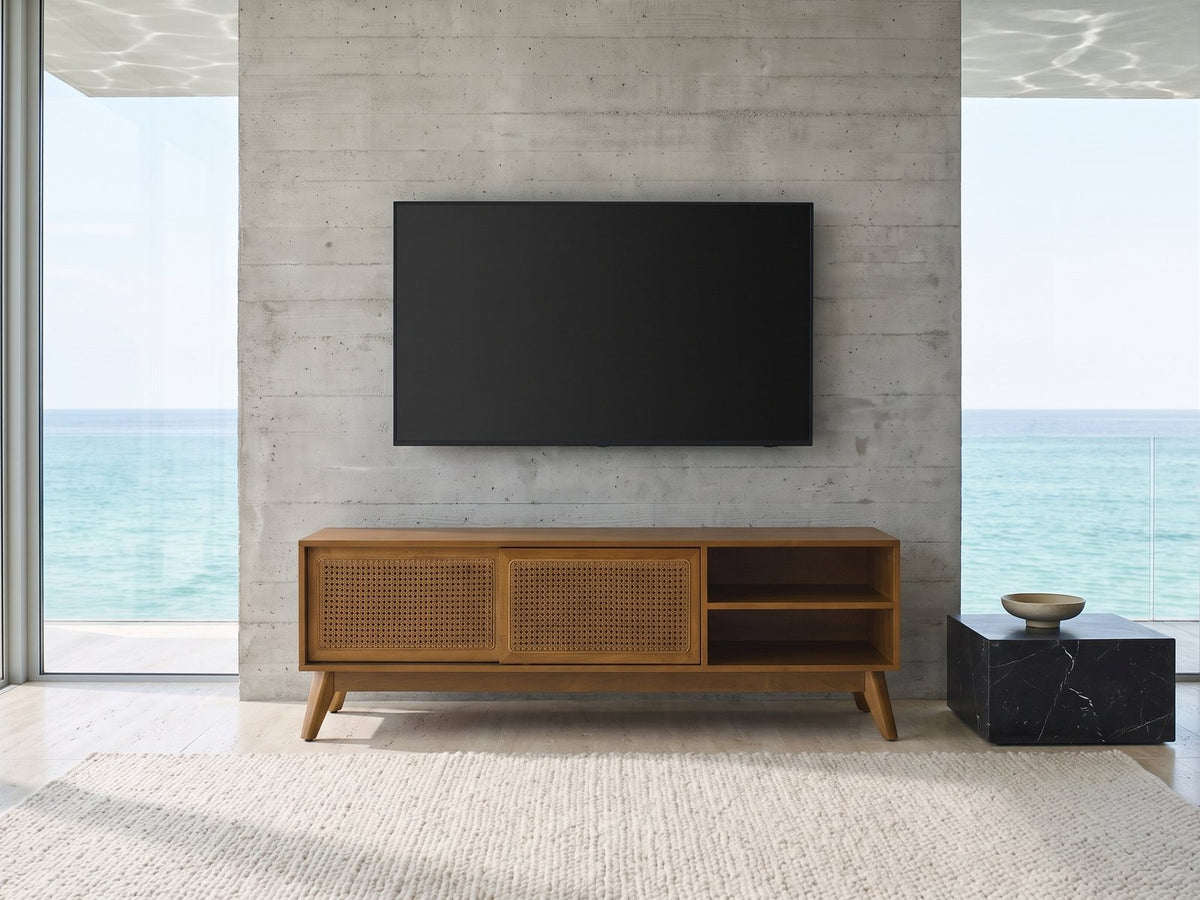 Cisternino 59-Inch Pecan Birch Veneer and Cane Media Console under a wall-mounted screen in an oceanfront glass house