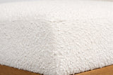 Close-up of the ivory boucle on the Citerna cushion: a dense, nubby weave of tiny loops, with the honey-brown frame below