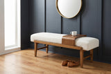 Citerna bench against a charcoal-blue panelled wall in a Nashville entry hall with a round brass mirror above, a white cup on the tray and a pair of loafers on the floor