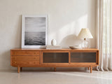 Cividale Solid Cherry Media Console styled with a leaning print, a lamp and ceramics in a bright plaster room