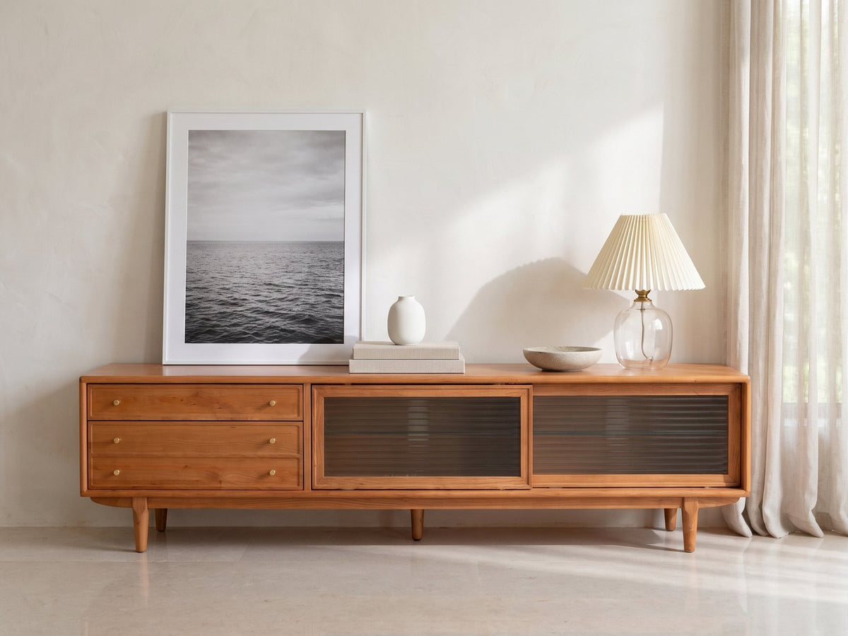 Cividale Solid Cherry Media Console styled with a leaning print, a lamp and ceramics in a bright plaster room